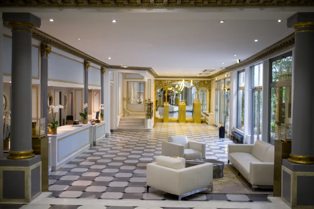Hall d'accueil élégant d'un hôtel parisien avec desk de réception et salon