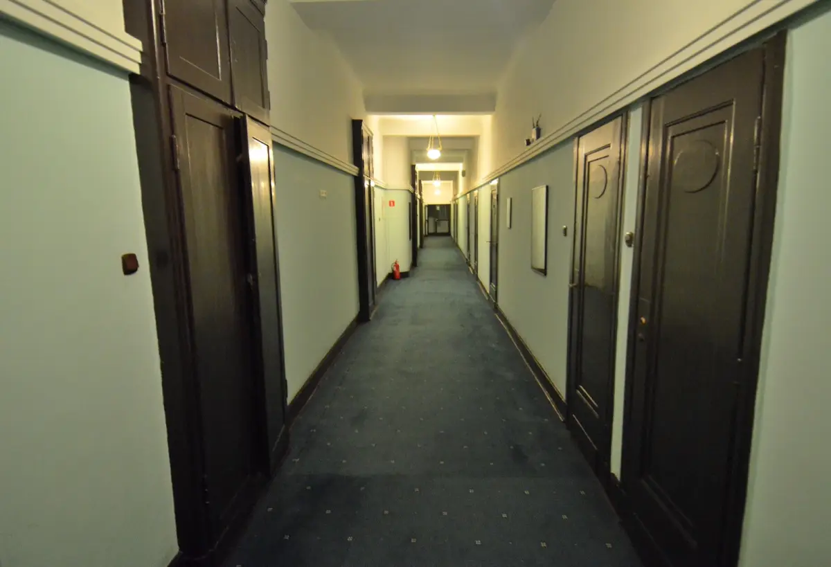 Couloir d'étage d'un hôtel avec portes en bois, symbole des chambres à synchroniser entre logiciels